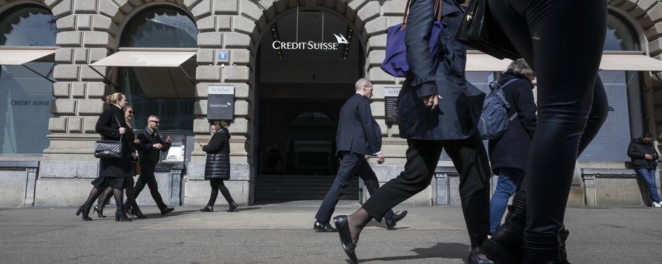 Les gens passent devant le bâtiment principal de Credit Suisse à Zurich, le 16 mars 2023. [Keystone - Ennio Leanza]