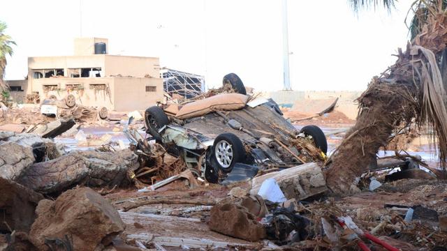 Un véhicule endommagé est coincé dans des débris après les inondations causées par la tempête Daniel à Derna, en Libye le 12 septembre 2023. [AFP - Abdullah Mohammed Bonja / Anadolu Agency]