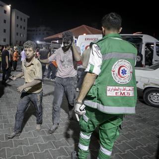 Des adolescents blessés sont assistés par des médecins militaires palestiniens à Gaza, le 9 octobre 2023. [Keystone/EPA - Haitham Imad]
