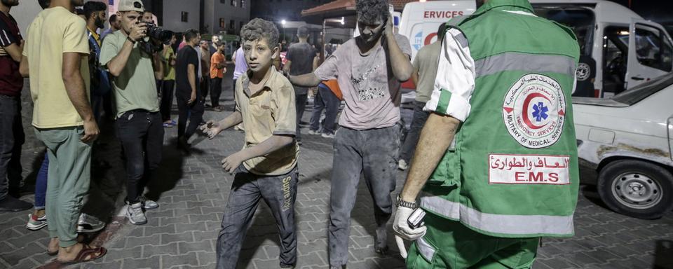 Des adolescents blessés sont assistés par des médecins militaires palestiniens à Gaza, le 9 octobre 2023. [Keystone/EPA - Haitham Imad]