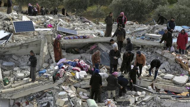 Des civils cherchent des survivants dans les débris des bâtiments d'Idlib, en Syrie. [Keystone - Ghaith Alsayed]