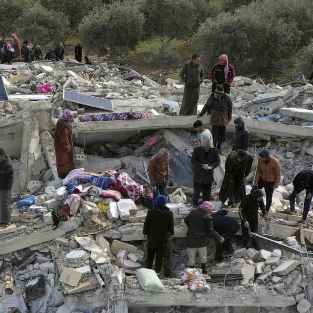 Des civils cherchent des survivants dans les débris des bâtiments d'Idlib, en Syrie. [Keystone - Ghaith Alsayed]