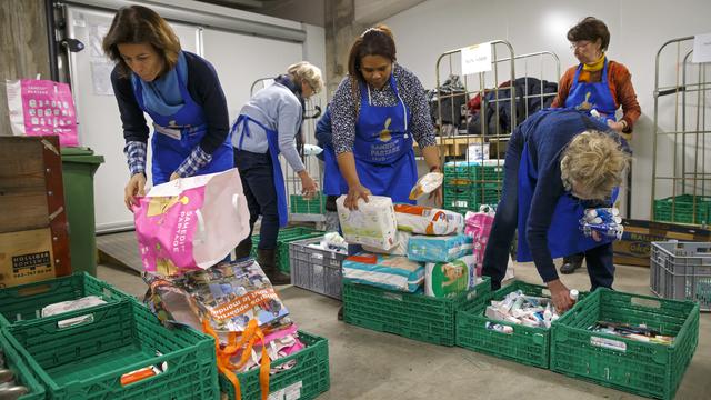 Des bénévoles préparant des sacs de marchandises pour les bénéficiaires. [Keystone - Salvatore Di Nolfi]