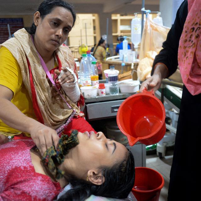 Des femmes s'occupent d'une patiente atteinte de dengue, au Mugda Medical College and Hospital à Dhaka au Bangladesh, le 8 août 2019. [AFP - MUNIR UZ ZAMAN / AFP]