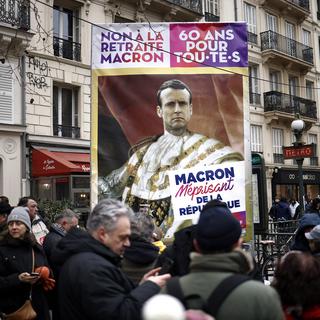 Un portrait du président Emmanuel Macron lors d'une manifestation de grève nationale contre le projet de réforme des retraites en France. [Keystone/EPA - Yoan Valat]