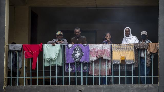 Des personnes déplacées, de la région du Tigrée au Nord de l'Éthiopie, regardent la préparation du repas dans la ville de Mekele. [Keystone/AP Photo - Ben Curtis]