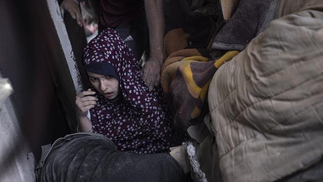 Une femme palestinienne est évacuée d'un immeuble détruit par l'armée israélienne à Gaza, le 5 novembre 2023. [Keystone/EPA - Haitham Imad]