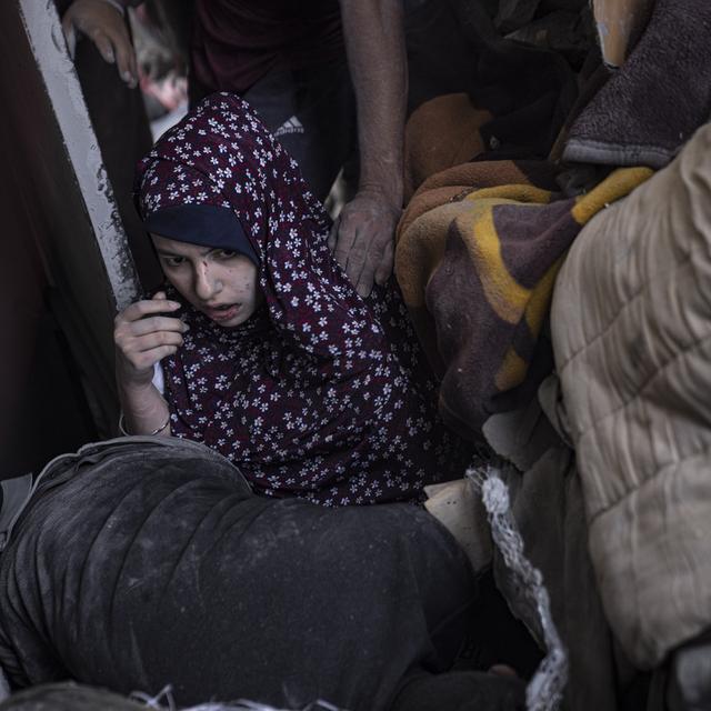 Une femme palestinienne est évacuée d'un immeuble détruit par l'armée israélienne à Gaza, le 5 novembre 2023. [Keystone/EPA - Haitham Imad]