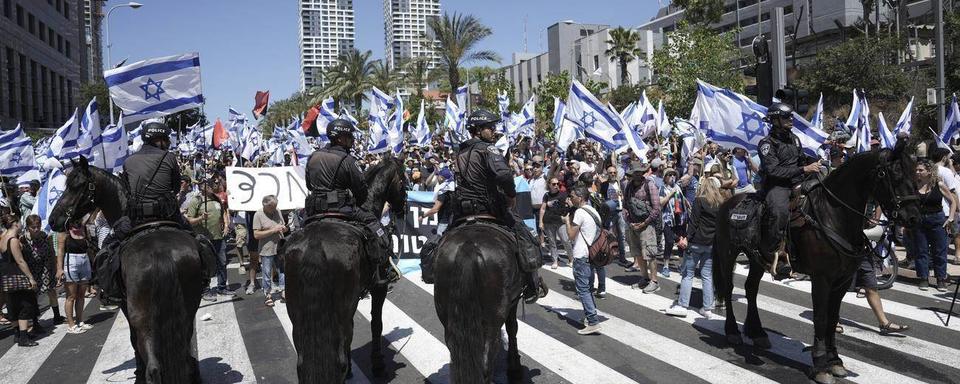 Des milliers de personnes manifestent mardi en Israël pour dénoncer le projet de réforme judiciaire. [Keystone]