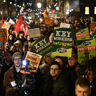 Des manifestants se sont rassemblés près de Downing Street à Londres le 30 janvier pour protester contre la proposition législative du gouvernement qui vise à garantir un service minimum dans le secteur public en cas de grève. [KEYSTONE - EPA/ANDY RAIN]