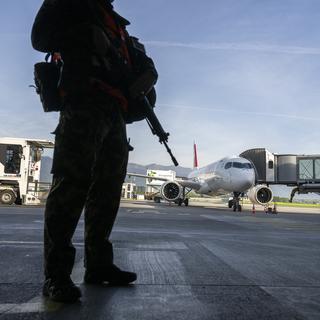 Un soldat de l'armée suisse surveille le tarmac de l'aéroport International de geneve (AIG), lors de l'exercice LUX 23 le 4 mai 2023. [Keystone - Martial Trezzini]
