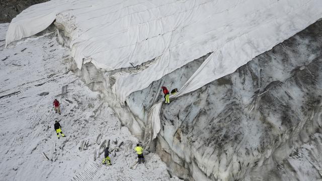 Pour lutter contre la fonte des glaciers, on les recouvre de bâches pendant l'été, comme ici au Corvatsch en 2022. [KEYSTONE - Gian Ehrenzeller]