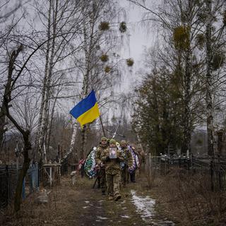 Des militaires ukrainiens transportant le corps d'un lieutenant décédé, vers Kiev. [Keystone/AP Photo - Emilio Morenatti]