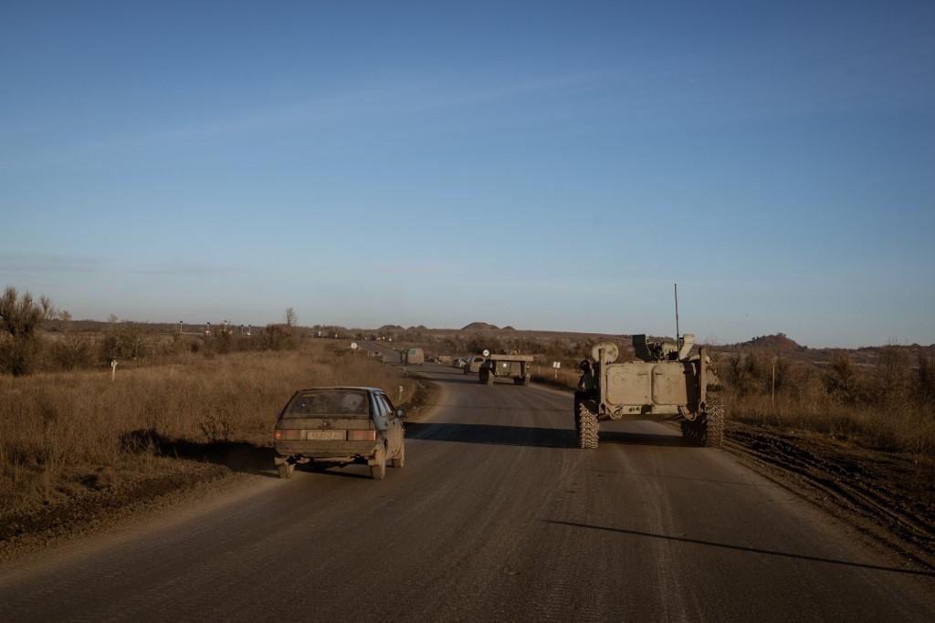Des véhicules militaires sur une route près de Bakhmout. [Keystone - Andre Luis Alves]