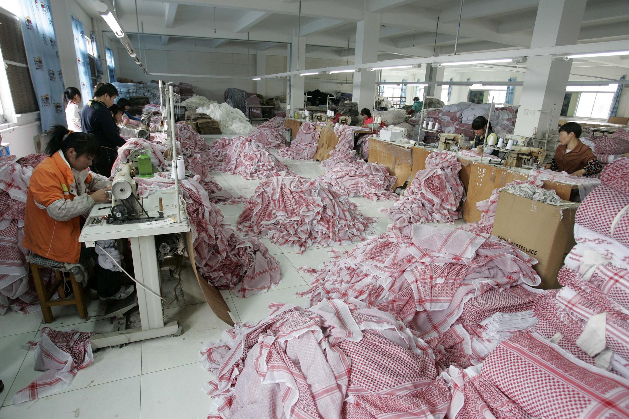 Des ouvriers travaillent sur la chaîne de production d'une usine fabriquant des foulards musulmans destinés à l'exportation. Leurs produits sont vendus aux commerçants du Moyen-Orient qui s'approvisionnent en produits bon marché dans la ville de Yiwu. [reuters - Aly Song]