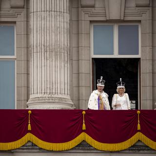 Le roi britannique Charles III et son épouse la reine Camilla au balcon de Buckingham Palace. [Keystone/AP Photo - Andreea Alexandru]