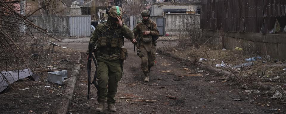 Des soldats ukrainiens dans une ruelle de Bakhmout, le 15 mars 2023. [AP/Keystone - Roman Chop]