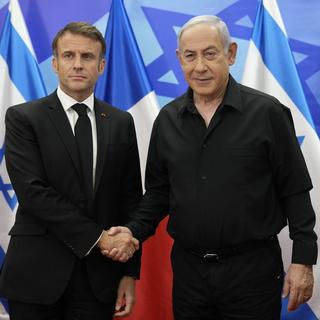 Emmanuel Macron serrant la main de Benjamin Netanyahu lors de sa visite à Jérusalem le 24.10.2023. [EPA/Keystone - Christophe Ena]
