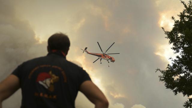 Un hélicoptère survole un incendie de forêt dans le village de Giannouli, dans la région nord-est d'Evros, en Grèce, le jeudi 31 août 2023. [Keystone]
