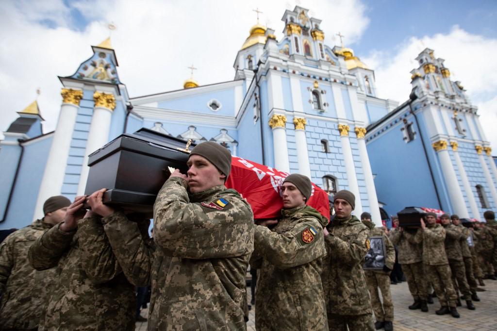 Des personnes assistent à Kiev à la cérémonie funéraire de quatre soldats ukrainiens, morts dans la région de Bryansk, le 7 mars 2023. [AFP - Oleksii Chumachenko / Anadolu Agency]