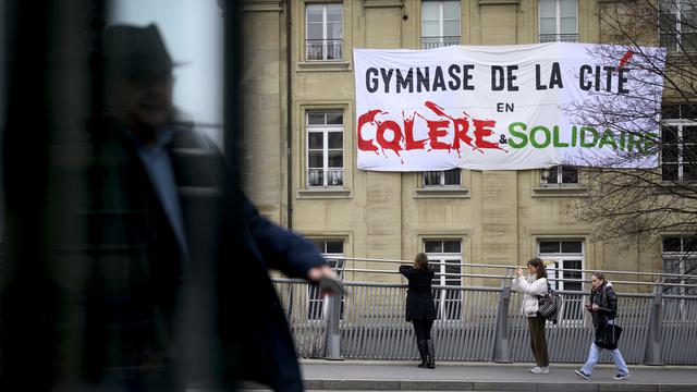 Une banderole "Colère & Solidaire" est suspendue sur la façade du Gymnase de la Cité lors de la 5eme journée d'actions et de grève de la fonction publique vaudoise, des salariés des secteurs publics a l'appel de leurs syndicats (FSF, SSP, SUD) ce mercredi 1er mars 2023 à Lausanne. [Keystone - Laurent Gillieron]