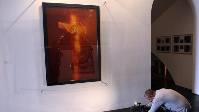 Un cameraman documente les dégâts causé à l'oeuvre "Immersion Piss Christ" de l'artiste américain Andres Serrano en avril 2011 à Avignon. [AFP - BORIS HORVAT]