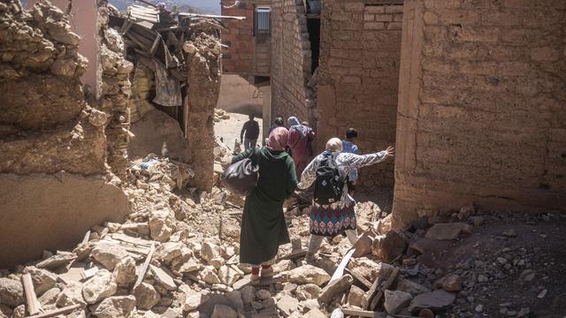 Des marocains fuient les décombres après le séisme au Maroc. [AP Photo/Keystone - Mosa'ab Elshamy]