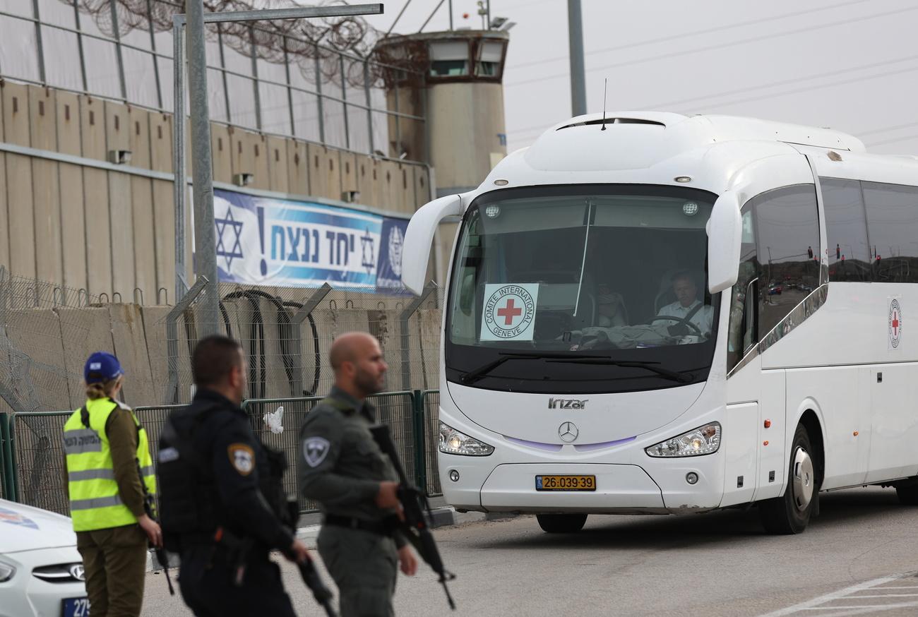 Le bus de la Croix-Rouge qui doit transporter des femmes et enfants palestiniens détenus dans une prison de Jérusalem vers Gaza, pour un échange avec des otages israéliens. [EPA/Keystone - Atef Safadi]