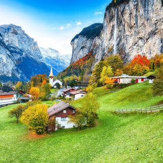 Incroyable paysage d'automne du village alpin touristique Lauterbrunnen avec célèbre église et cascade Staubbach. Lieu : Lauterbrunnen village, Berner Oberland, Suisse, Europe. [Depositphotos - ©Pilat666]