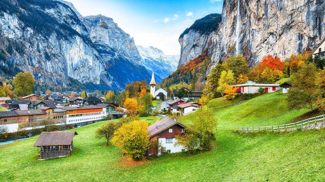 Incroyable paysage d'automne du village alpin touristique Lauterbrunnen avec célèbre église et cascade Staubbach. Lieu : Lauterbrunnen village, Berner Oberland, Suisse, Europe. [Depositphotos - ©Pilat666]