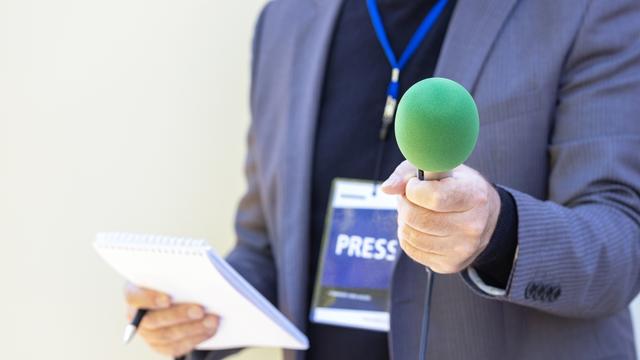 Reporter tenant microphone faisant entrevue avec les médias. [Depositphotos - ©Macor]