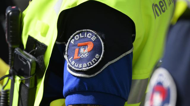 Le badge de la police de Lausanne sur l'uniforme d'un policier. [Keystone - Laurent Gillieron]