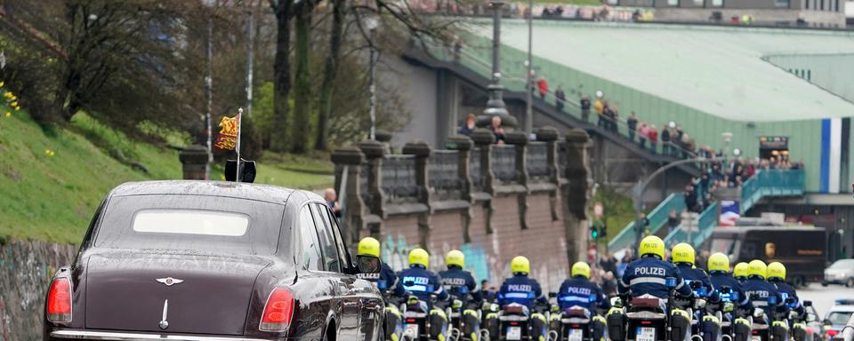 Vendredi 31 mars: la limousine du roi Charles III de Grande-Bretagne et de son épouse Camilla sous escorte policière à Hambourg au terme de leur voyage de trois jours en Allemagne. [Keystone/DPA - Marcus Brandt]