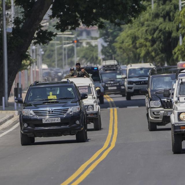 Les délégués sont escortés par la police indienne à leur arrivée pour le G20 à Cachemire. [Ap Photo / Keystone - Mukhtar Khan]