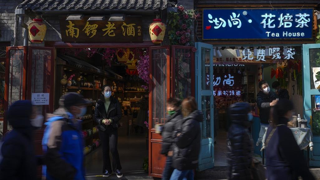 Quelques personnes se baladent devant des boutiques à Beijing en mars 2023. [Keystone/AP Photo - Andy Wong]