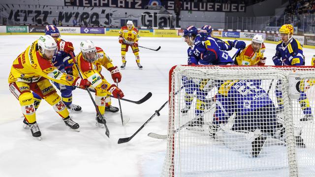 Mike Kuenzle trompe ici Juha Metsola et enterre pour de bon les petits espoirs de Kloten dans ce match. [Keystone - Patrick B. Kraemer]