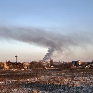 De la fumée s'échappe de Soledar, une ville de l'est de l'Ukraine, après un bombardement le 8 janvier 2023. [Keystone - AP Photo/Roman Chop]