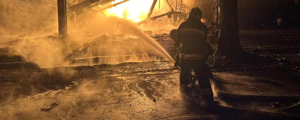 Des pompiers à l'oeuvre pour éteindre un incendie dans une raffinerie de pétrole à Kremenchouk. [Reuters - Filip Pronin/Poltava Regional Military Administration]