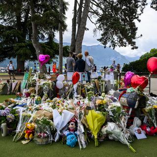 Des fleurs  sont visibles à l'aire de jeux des enfants après une attaque au couteau à Annecy, France, 10 juin 2023. [Keystone - Jean-Christophe Bott]