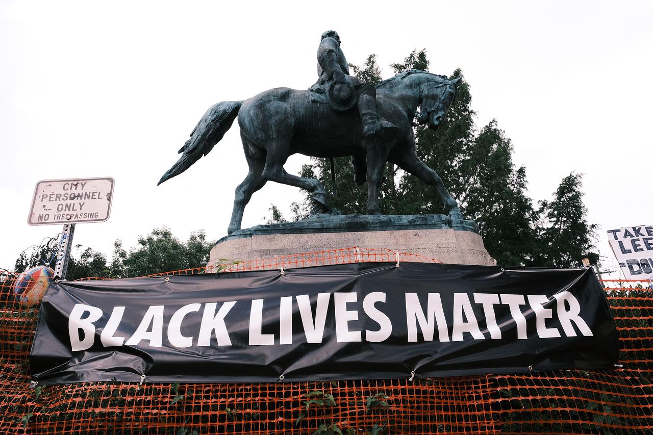 La statue du militaire américain Robert E. Lee aux côtés d'une banderole "Black Lives Matter" à Charlottesville, Virginie, en août 2020. [AFP - Eze Amos]