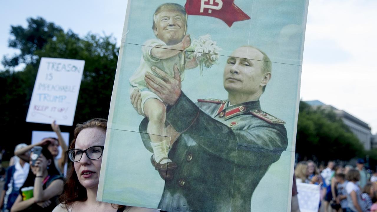 Une activiste américaine avec une pancarte dénonçant le rapprochement de la présidence américaine de Donald Trump avec la Russie de Vladimir Poutine en 2018. [Keystone/AP Photo - Andrew Harnik]