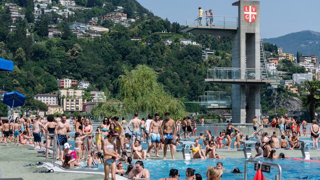 La piscine de Lugano est remplie de gens venus chercher la fraîcheur de l'eau en cette 4e journée de canicule (18.06.2022). [Keystone - Ti-Press/Elia Bianchi]