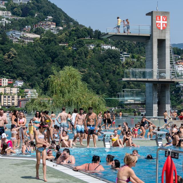 La piscine de Lugano est remplie de gens venus chercher la fraîcheur de l'eau en cette 4e journée de canicule (18.06.2022). [Keystone - Ti-Press/Elia Bianchi]