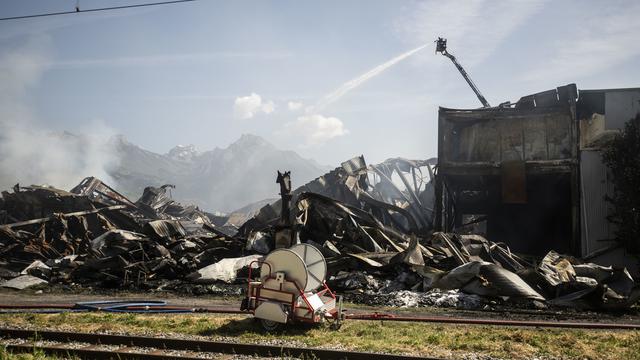 L'incendie, qui a duré toute la nuit, a complètement ravagé la halle industrielle à Vétroz. [Keystone - Louis Dasselborne]