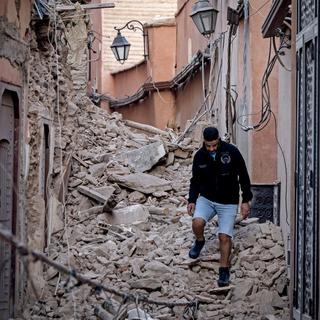 Un habitant se fraye un chemin dans les décombres après le séisme à Marrakech, le 9 septembre 2023. [AFP - FADEL SENNA]