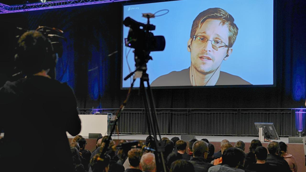 Edward Snowden est intervenu par visioconférence à de nombreuses reprises, comme ici à Leipzig. [Keystone/DPA - Sebastian Willnow]