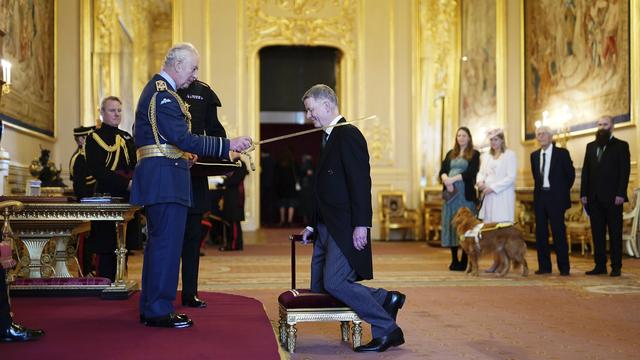 Le roi Charles III nomme à chaque nouvelle année de nouveaux membres des ordres de chevalerie, comme ici, le chef des services secrets Richard Moore qui est fait Compagnon d'honneur le 19 décembre 2023. [AP / Keystone - Aaron Chown]