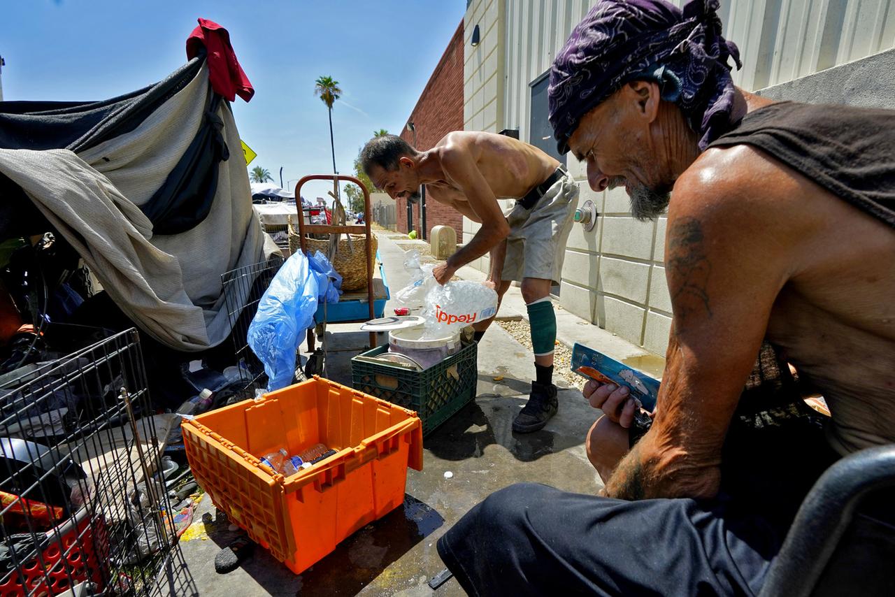 Deux sans-abri luttent contre la chaleur dans leur campement à Phoenix. Les sans-logis figurent parmi les premières victimes des températures extrêmes qui frappent les Etats-Unis. [Keystone - Matt York/AP Photo]