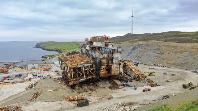 Un puits pétrolier à l'abandon et une éolienne vers Lerwick, dans les Shetland. [AFP - William Edwards]