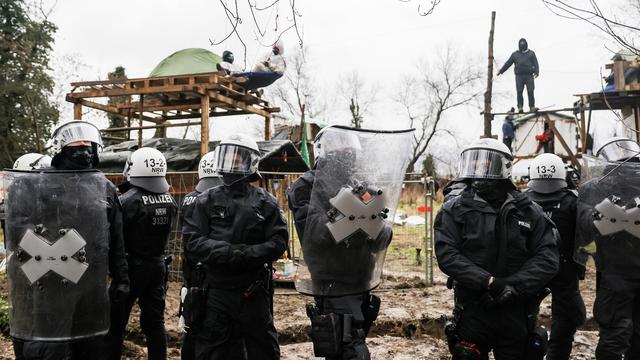 Des officiers de polices montent la garde durant l'opération de délogement des activistes pour le climat établis à Lüzerath. [EPA/Keystone - RONALD WITTEK]